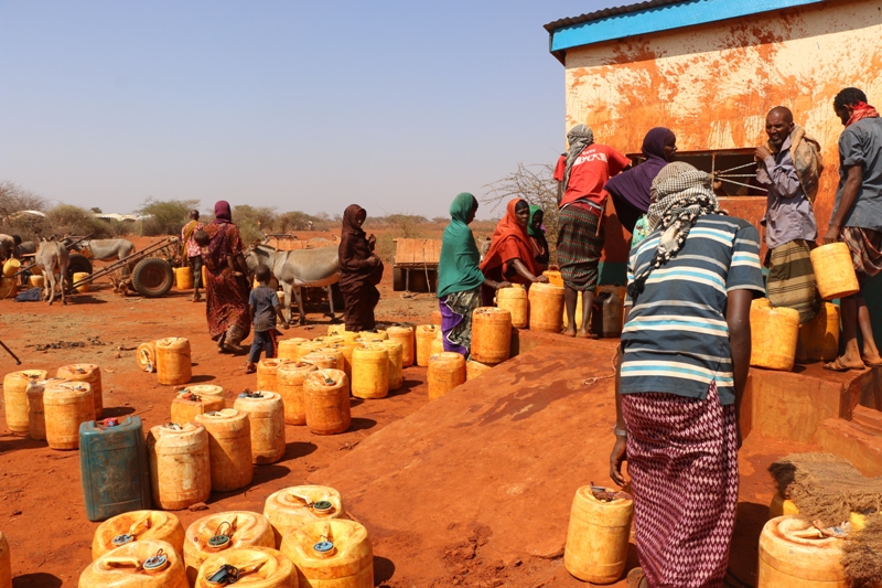 Women fetching water at a water kiosk in Wajirclimate finance lessons kenya 
